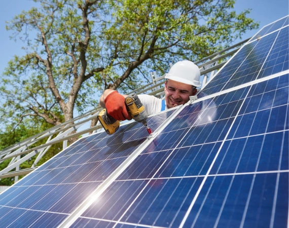 worker installing solar panels on roof in Los Angeles by your adu guy